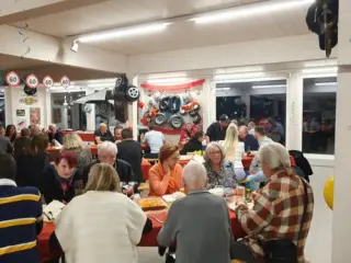 Gäste an den Tischen, an der Wand Oldtimer-Reifen und Dekoration